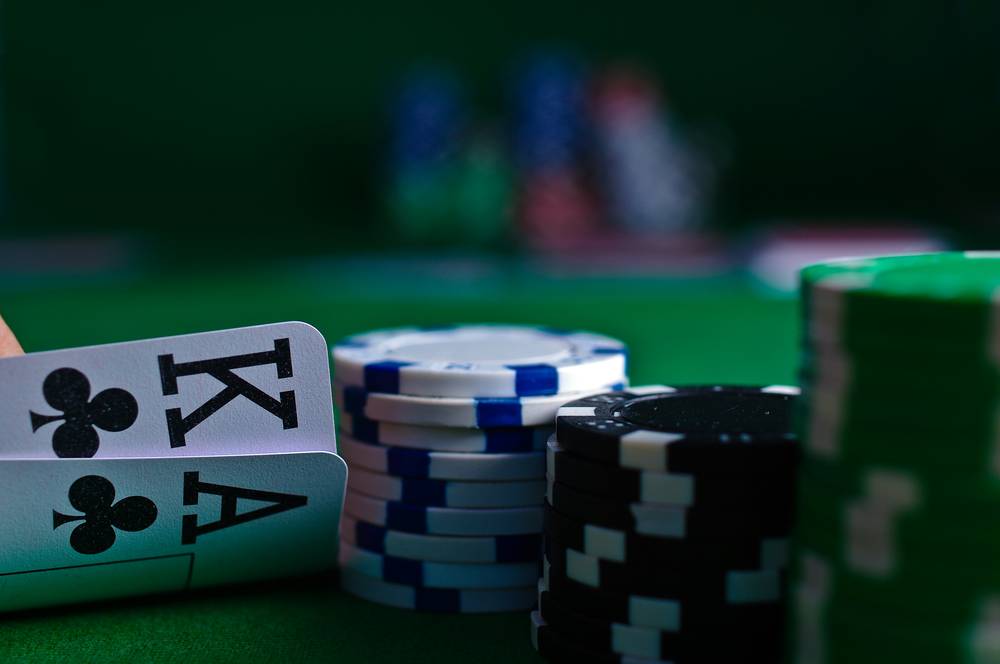 Kartu remi dan chip poker tersusun rapi sebagai ilustrasi artikel membaca syarat bonus